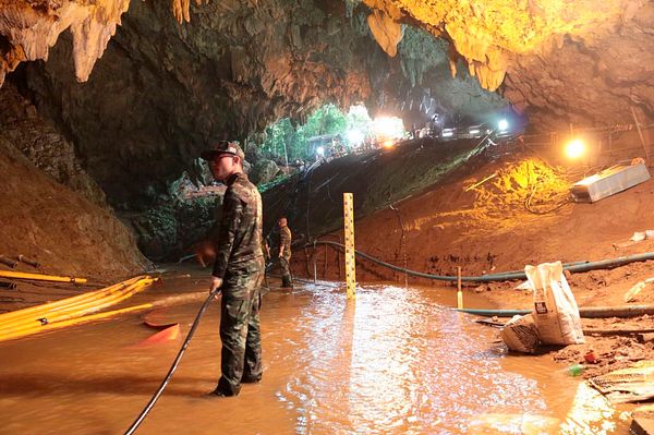 Rescue divers and Thai Navy SEALs guiding a young Wild Boars soccer team member on a stretcher through the flooded Tham Luang cave in northern Thailand during the dramatic July 2018 rescue operation that saved 12 boys and their coach.