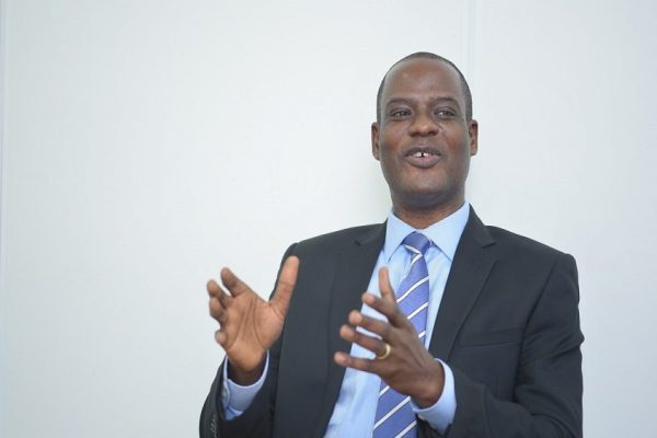 "Taiwo Oyedele speaking at a press briefing on Nigeria's new tax laws, with a backdrop of the Presidential Fiscal Policy and Tax Reforms Committee logo