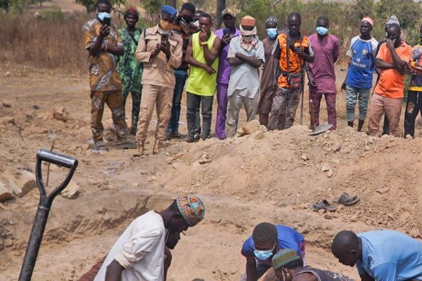 Survivors and community members gather near destroyed homes in Woro village, Kwara State, following February 3, 2026 armed attack that killed over 170 residents