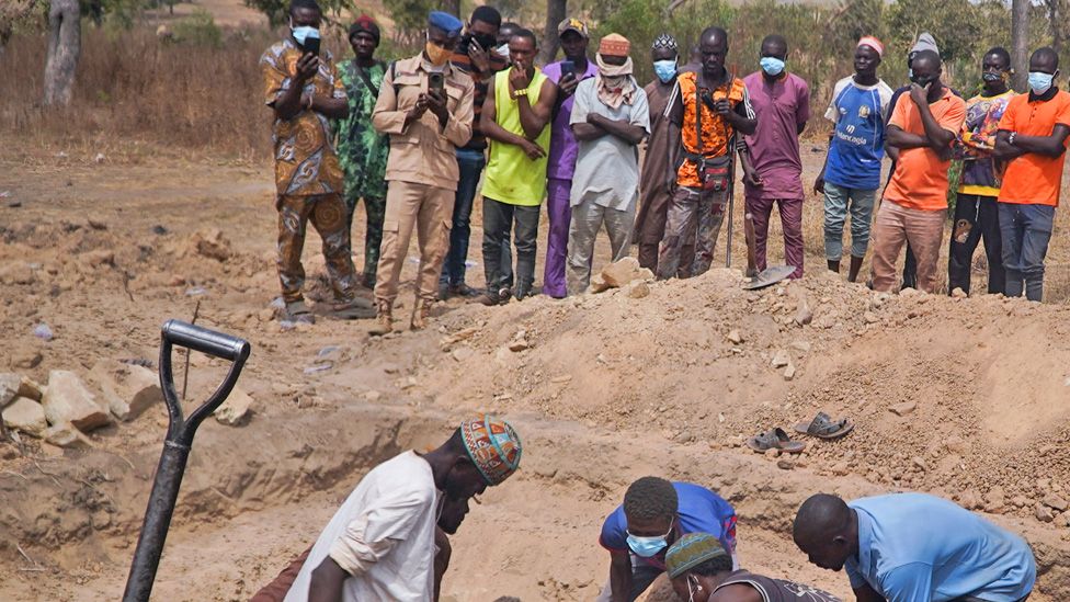 Survivors and community members gather near destroyed homes in Woro village, Kwara State, following February 3, 2026 armed attack that killed over 170 residents