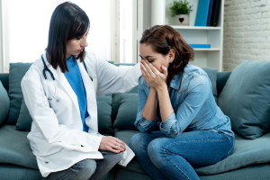 A compassionate female doctor comforting and consulting with a woman in a modern medical clinic about miscarriage, pregnancy loss, recovery, and reproductive health.